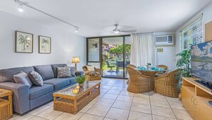A living room with a sofa, coffee table, wicker chairs, and a TV. - 3-Min Walk to Beach! Ground Floor - No Resort Fee (Kihei)