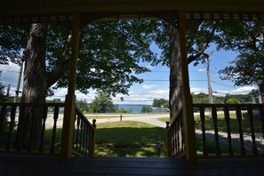 A covered porch with a view of a lake and a road. - Updated Historic Cape overlooking the famous Winnisquam Sandbar  (Belmont)