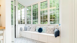 A room with a white bench along a window with multiple panes, a patterned floor, and a white door. - Estate4home - The Attic (Sorrento)