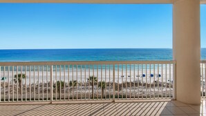 A balcony with a view of a beach, a tiled floor, and a white railing. - 🌊Silver Beach 603E | Beach Front | Upscale + Disc. Beach Service (Destin)