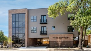 A modern building with a brick facade, large windows, and a sign reading "THE SCOTAIN".