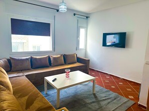 Appartement Confort | Coin séjour | TV connectée de 43 pouces avec chaînes par satellite, Netflix