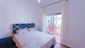 A bedroom with a bed, a hanging chair, and a view of the outside. - Apartment with pool direct access to sea (Oued Laou)