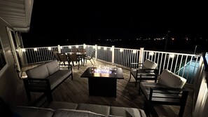 Une terrasse avec un foyer, des sièges et une rambarde.