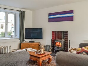 A living room with a television, a fireplace, a wooden coffee table, and two sofas. - 3 bedroom accommodation in Leitholm, near Coldstream (Leitholm, near Coldstream)