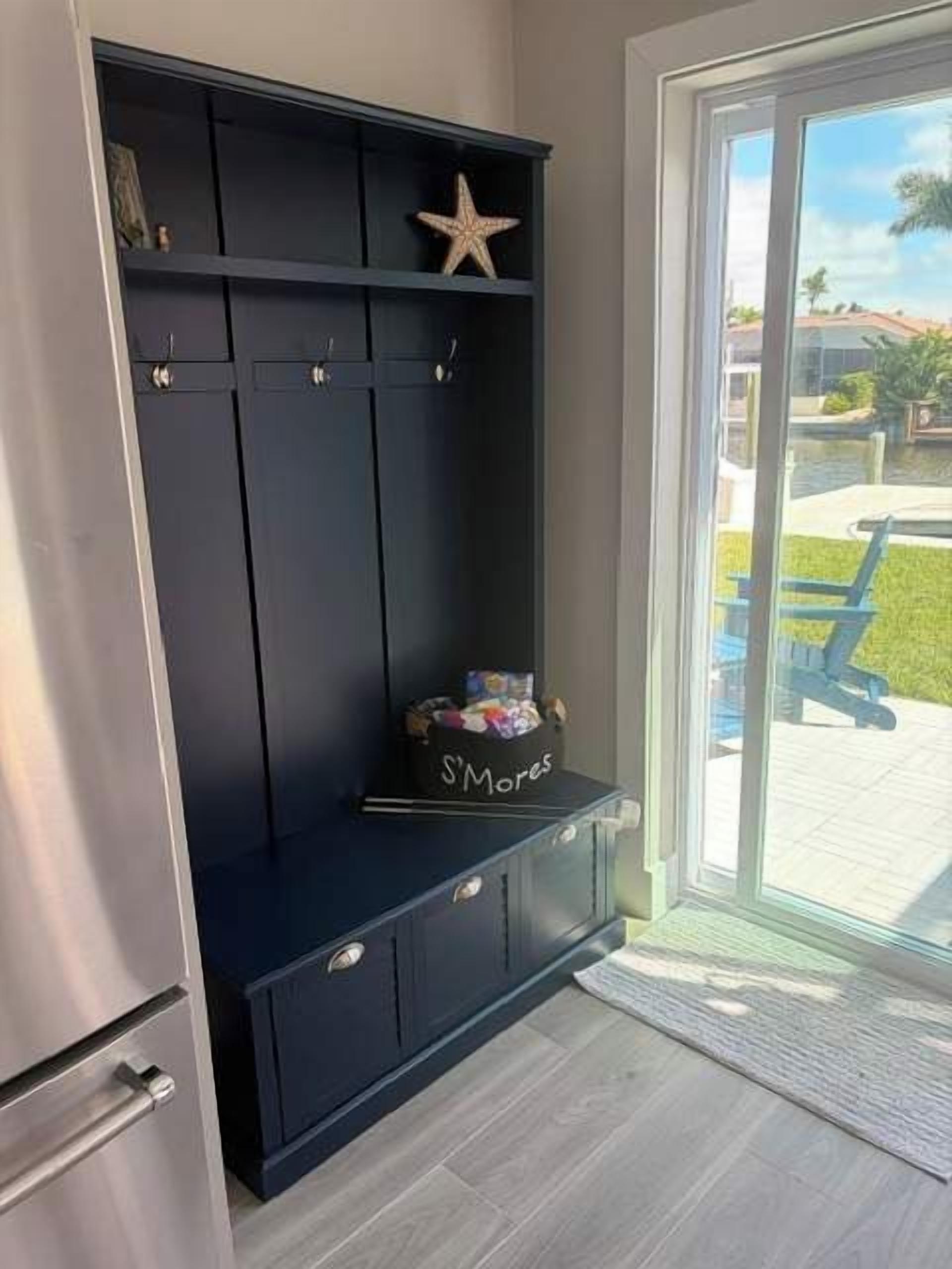 Een donkerblauwe garderobe met verschillende vakken en een sterdecoratie bovenaan.