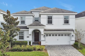 A two-story house with a white exterior, a tiled roof, and a garage. - 8BR Near Disney•6 Kings•Heated Pool•Star Wars (Davenport)