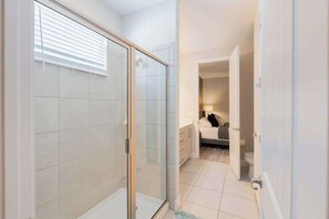 Ein modernes Badezimmer mit Duschkabine aus Glas, Toilette und Waschbecken.