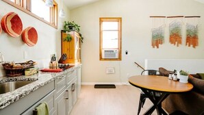 A kitchen with granite countertops, a wooden cabinet, and a dining area with a round table and chairs.