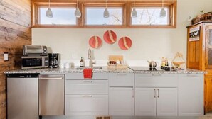 A modern kitchen with a large island, built-in appliances, and a wooden accent wall.