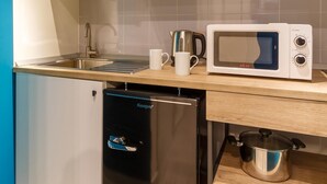 A compact kitchen with a built-in dishwasher, a microwave, and a coffee maker on the countertop. - Central Station Apts by Wonderful Italy - Cetara (Naples)