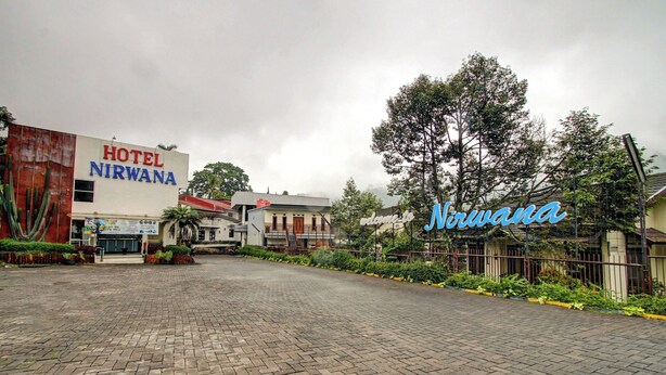 Un hotel llamado Nirwana, con entrada pavimentada y un letrero grande.