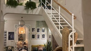 A multi-level interior with a staircase, seating areas, and decorative elements. - Riad Privado no Coração da Medina - Dar el Bacha (Marrakech)