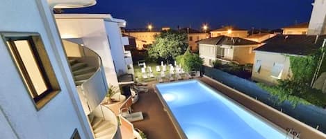 Una piscina al aire libre de temporada, sombrillas