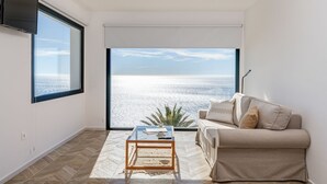 A modern living room with a large window, a flat-screen TV, a glass coffee table, and a beige sofa. - Villa Sofia - Four Bedroom Villa, Sleeps 10 (Salobreña)