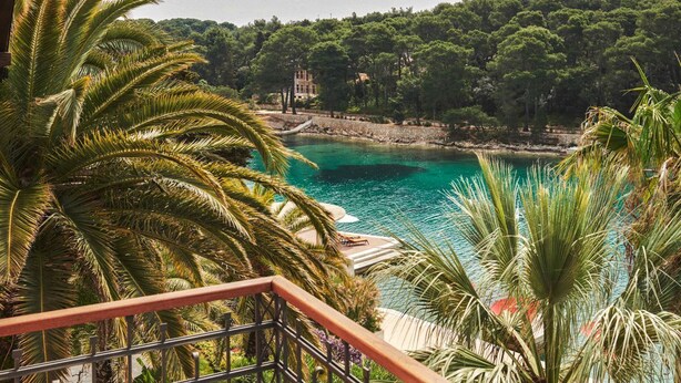 A coastal view with a clear turquoise sea, a rocky shoreline, and dense green trees in the background. - Villa Mirasol - Eight Bedroom Villa, Sleeps 16 (Mali Losinj)