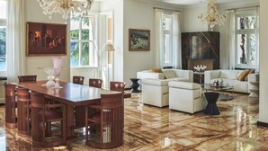 A spacious living room with a marble floor, a dining area with a wooden table and chairs, and a fireplace. - Villa Mirasol - Eight Bedroom Villa, Sleeps 16 (Mali Losinj)