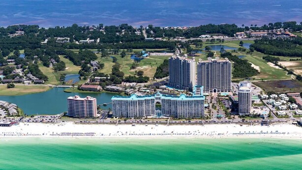 A coastal hotel with multiple high-rise buildings, a beachfront, and surrounding greenery. - Studio~Private beach~Restaurant on site~ (Miramar Beach)