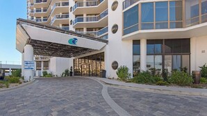 A modern building with a covered entrance, a logo, and a sign indicating 'Thru Traffic' and 'Load & Unload Only'. - Studio~Private beach~Restaurant on site~ (Miramar Beach)