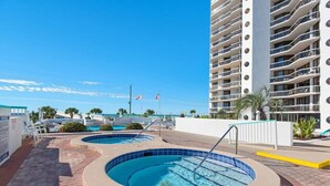 A hotel with a rooftop pool area, multiple swimming pools, and a high-rise building with balconies. - Studio~Private beach~Restaurant on site~ (Miramar Beach)