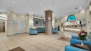 A spacious lobby with a central column, seating area, reception desk, and a large mirror. - Studio~Private beach~Restaurant on site~ (Miramar Beach)