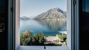 A view from a window overlooking a lake with mountains in the background.
