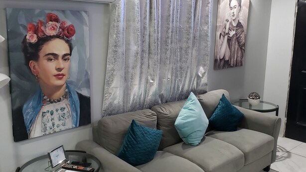 A living room with a grey sofa, teal cushions, a glass coffee table, and two framed artworks on the wall. - Private Gorgeous Cozy Modern home/5 min Drive from beach, righ across from park (Tijuana)