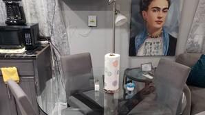 A modern kitchen with a glass dining table, grey chairs, a coffee machine, and a painting on the wall. - Private Gorgeous Cozy Modern home/5 min Drive from beach, righ across from park (Tijuana)
