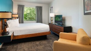 A hotel room with a bed, a television, a desk with a lamp, a chair, and a window with curtains. - Stay at a 1950s Classic Motel in Bozeman (Bozeman)