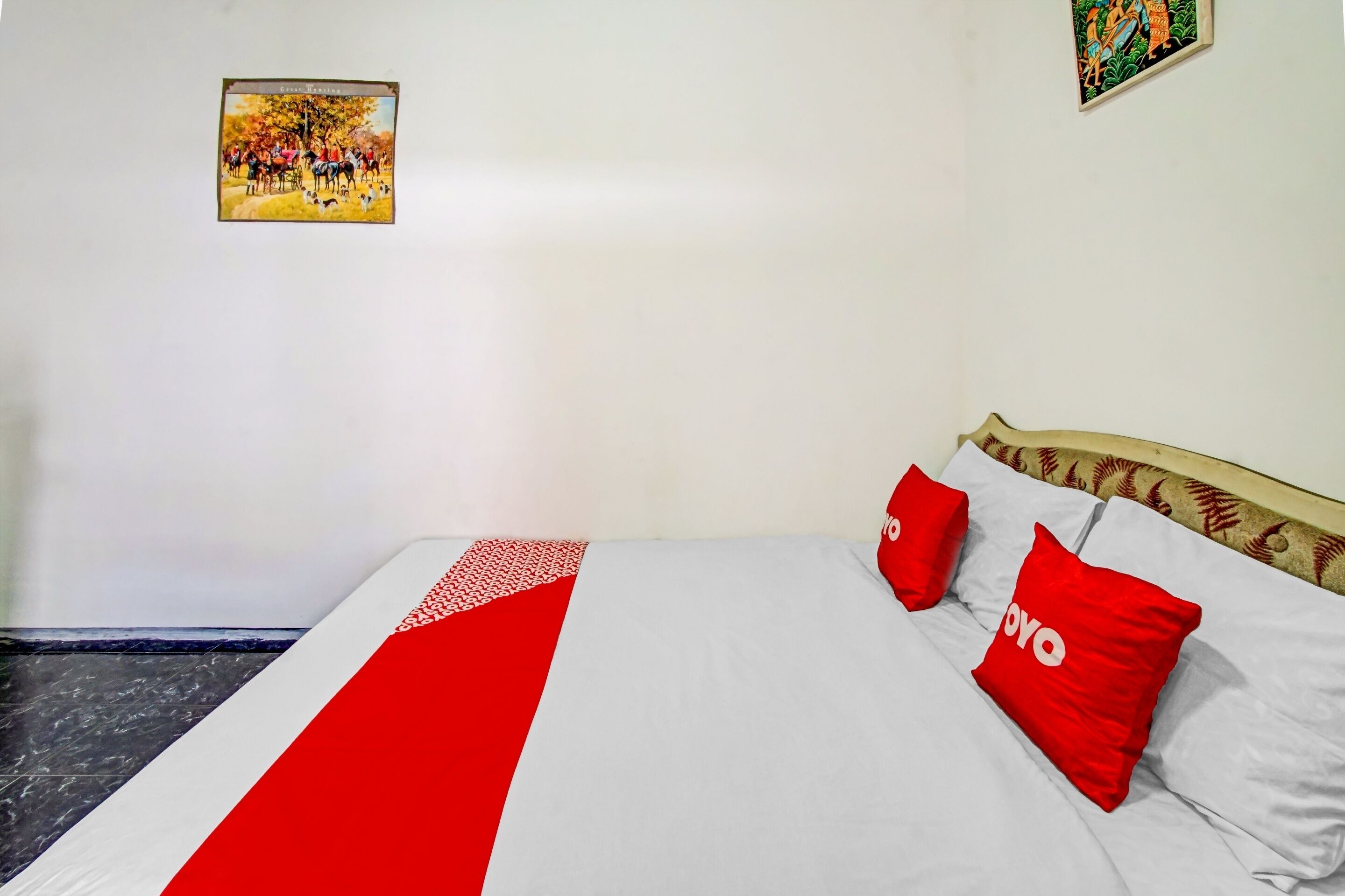 Una cama con una colcha roja y blanca, dos almohadas rojas con la palabra 