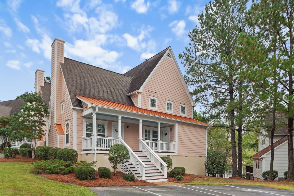 A two-story house with a front porch, a staircase, and a driveway.