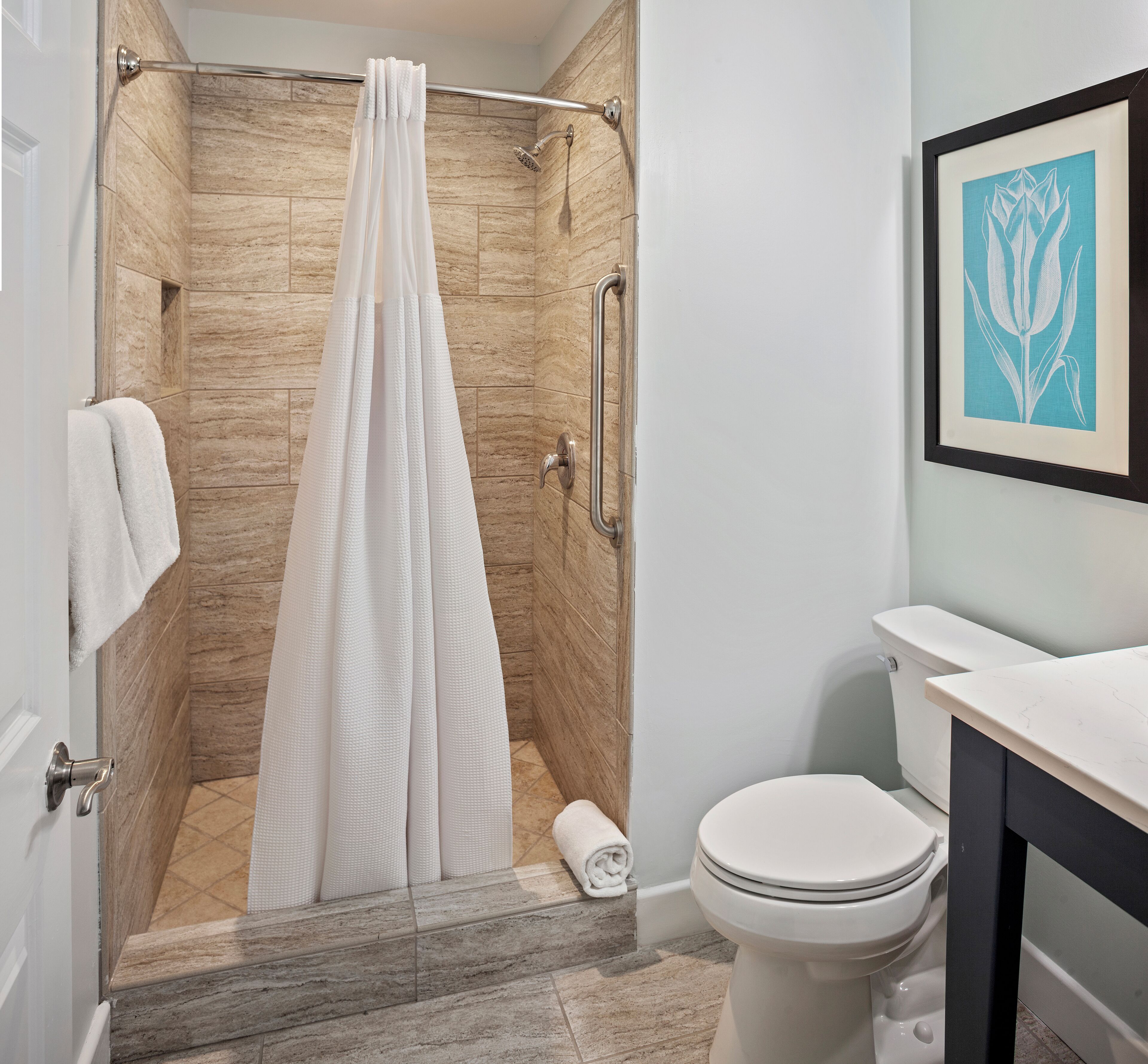 Een moderne badkamer met douche, toilet en wastafel.