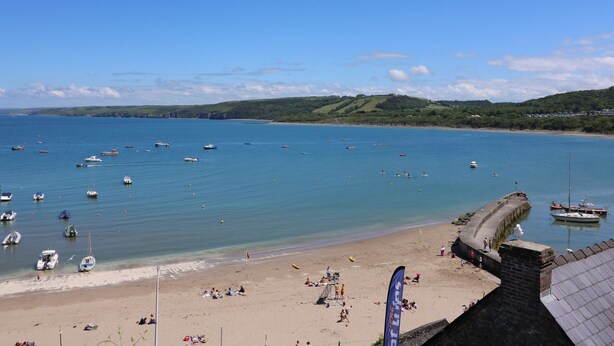 A coastal beach with boats, a sandy shore, and a stone wall. - Towyn Hall (New Quay)