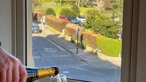 A window view of a street with parked cars and a building in the background. - Stylish Apartment with views, lift and parking (Scarborough)