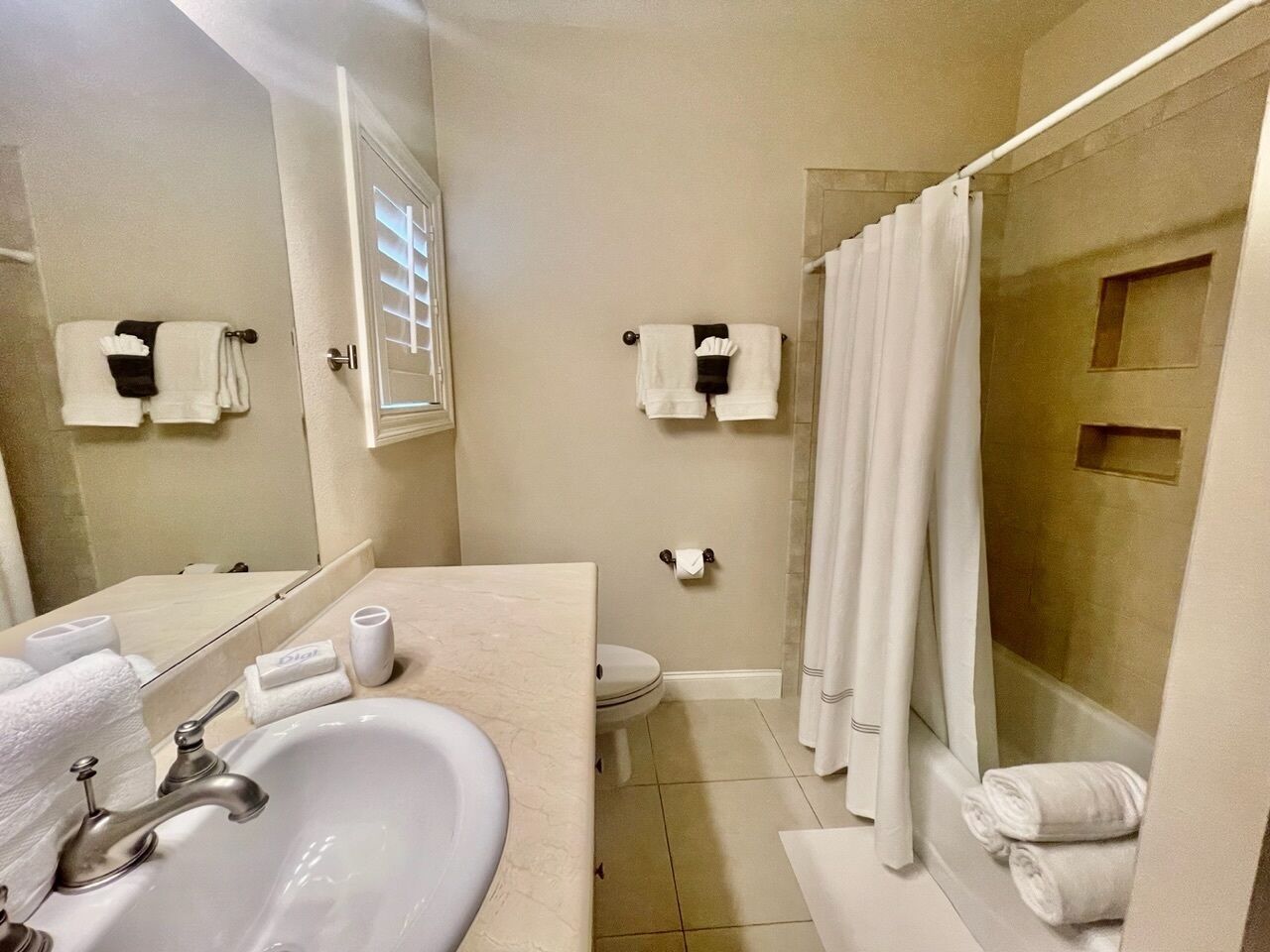 A bathroom with a sink, toilet, and shower area.