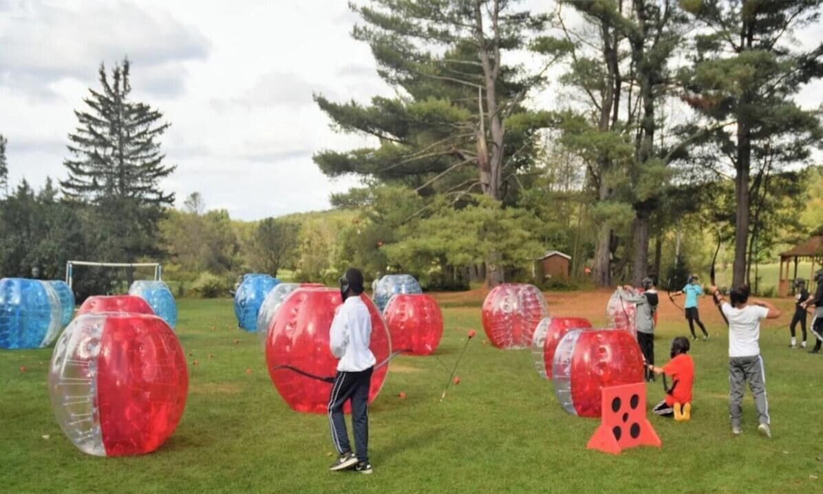An outdoor activity area with large transparent balls and participants.