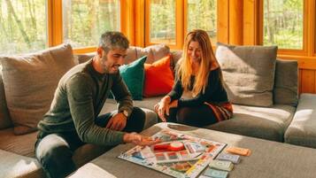 Dos personas sentadas en un sofá con un juego de mesa delante.