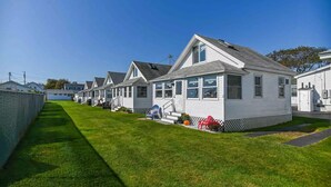 A row of white mobile homes with a grassy lawn in front. - Long Sands Beach Cottage in York (York)