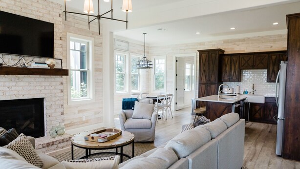 A spacious living room with a fireplace, a large sofa, and a dining area with a table and chairs. - Kaya Cottages (Cleveland)