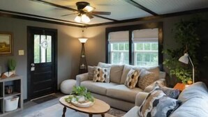 A cozy living room with a sofa, coffee table, and ceiling fan. - Mountain Cabin in Jamestown (Jamestown)
