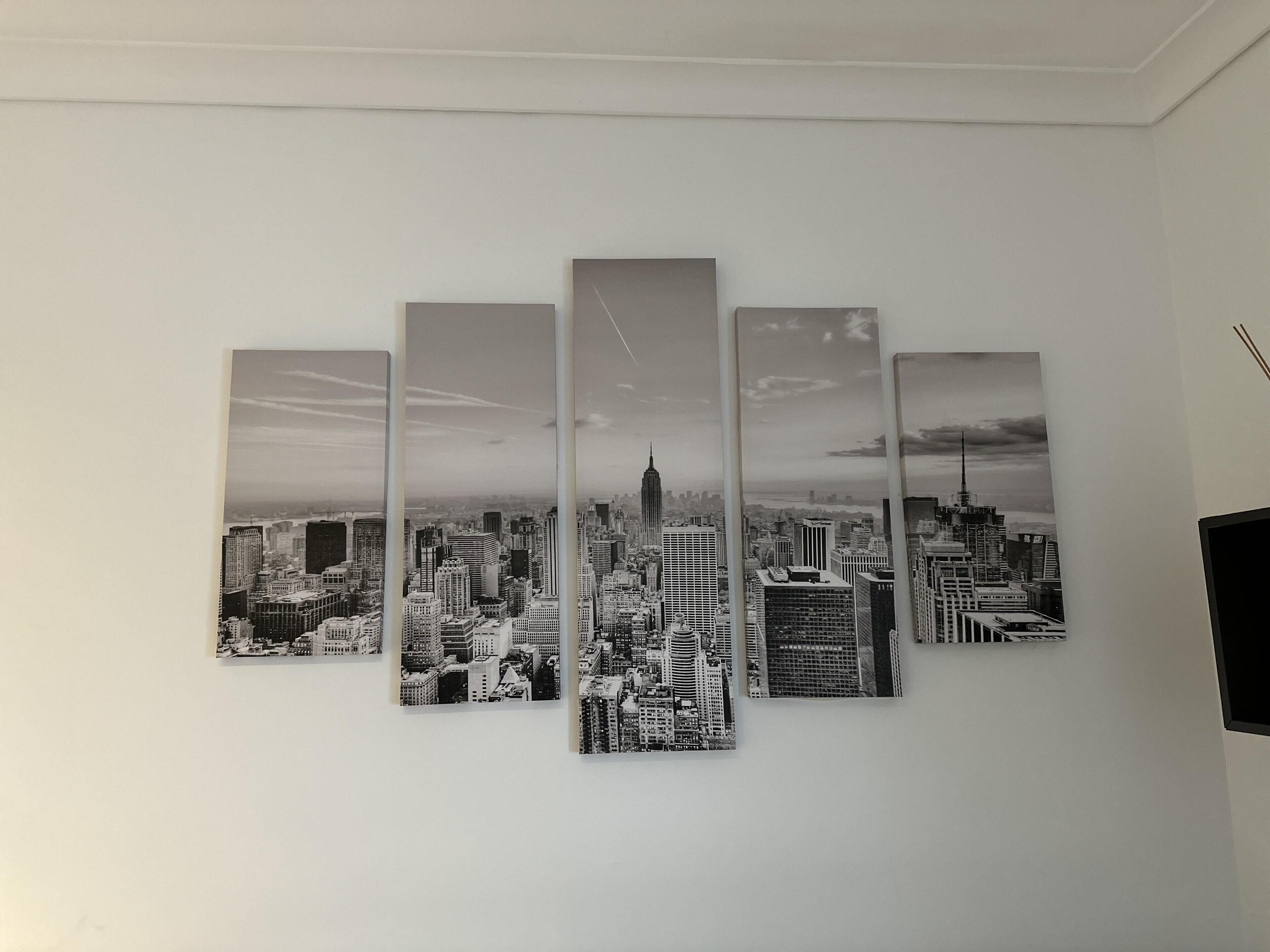 A wall with a five-panel cityscape artwork.