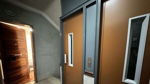 A hallway with a wooden door, a sliding door, and a door with a window. - Central Lisbon by Trip2Portugal (Lisbon)