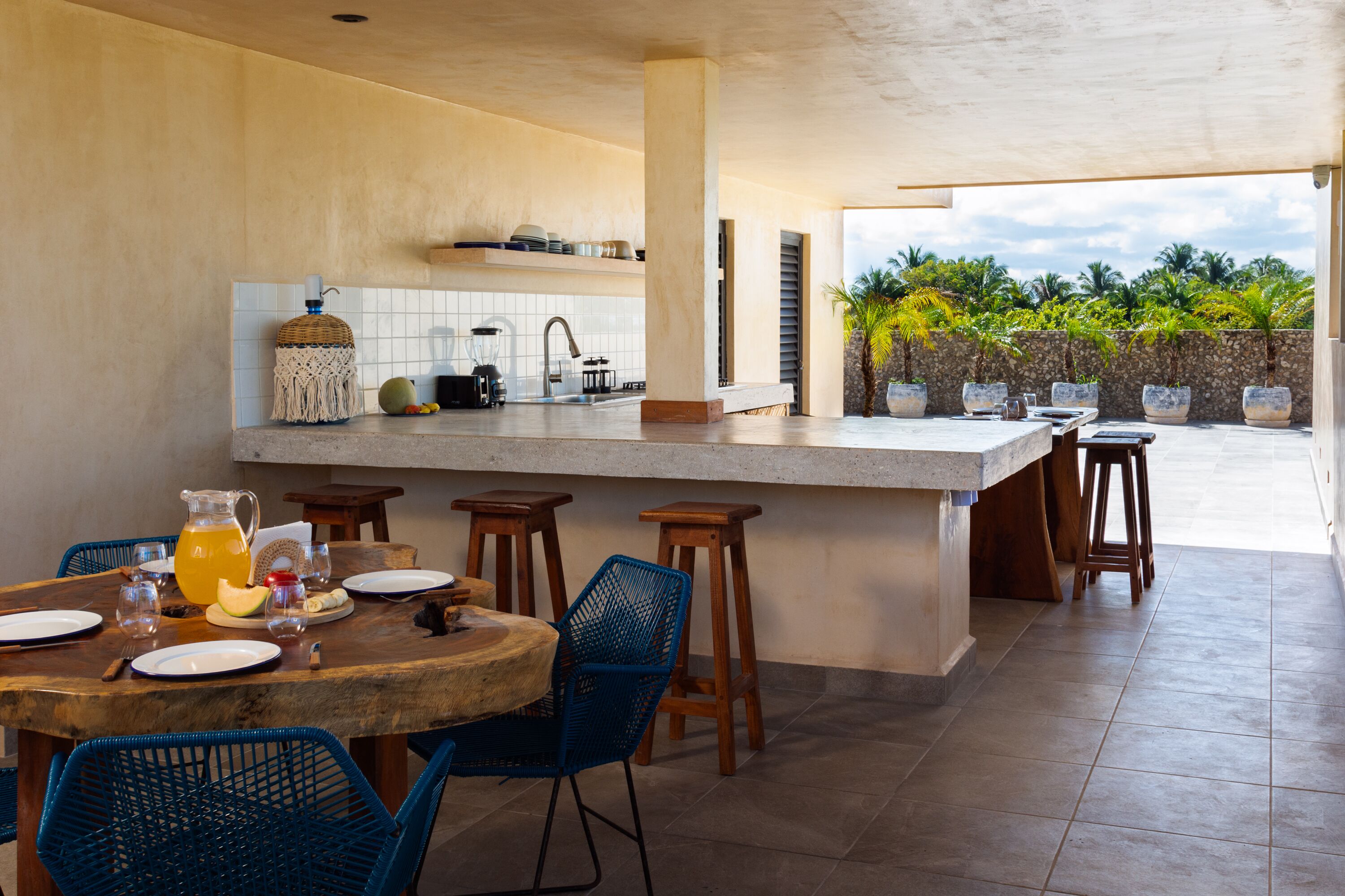 A modern kitchen with a large island, bar stools, and a dining table set for four.