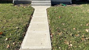 A two-story house with a front porch, a front door, and a small set of steps leading to the entrance. - PERFECT - LARGE CUSTOM HOME - Completely Renovated, Beautiful Fenced in Yard!!!! (Indianapolis)