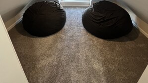 A small attic room with two bean bags, a sloped ceiling, and a window with blinds. - PERFECT - LARGE CUSTOM HOME - Completely Renovated, Beautiful Fenced in Yard!!!! (Indianapolis)