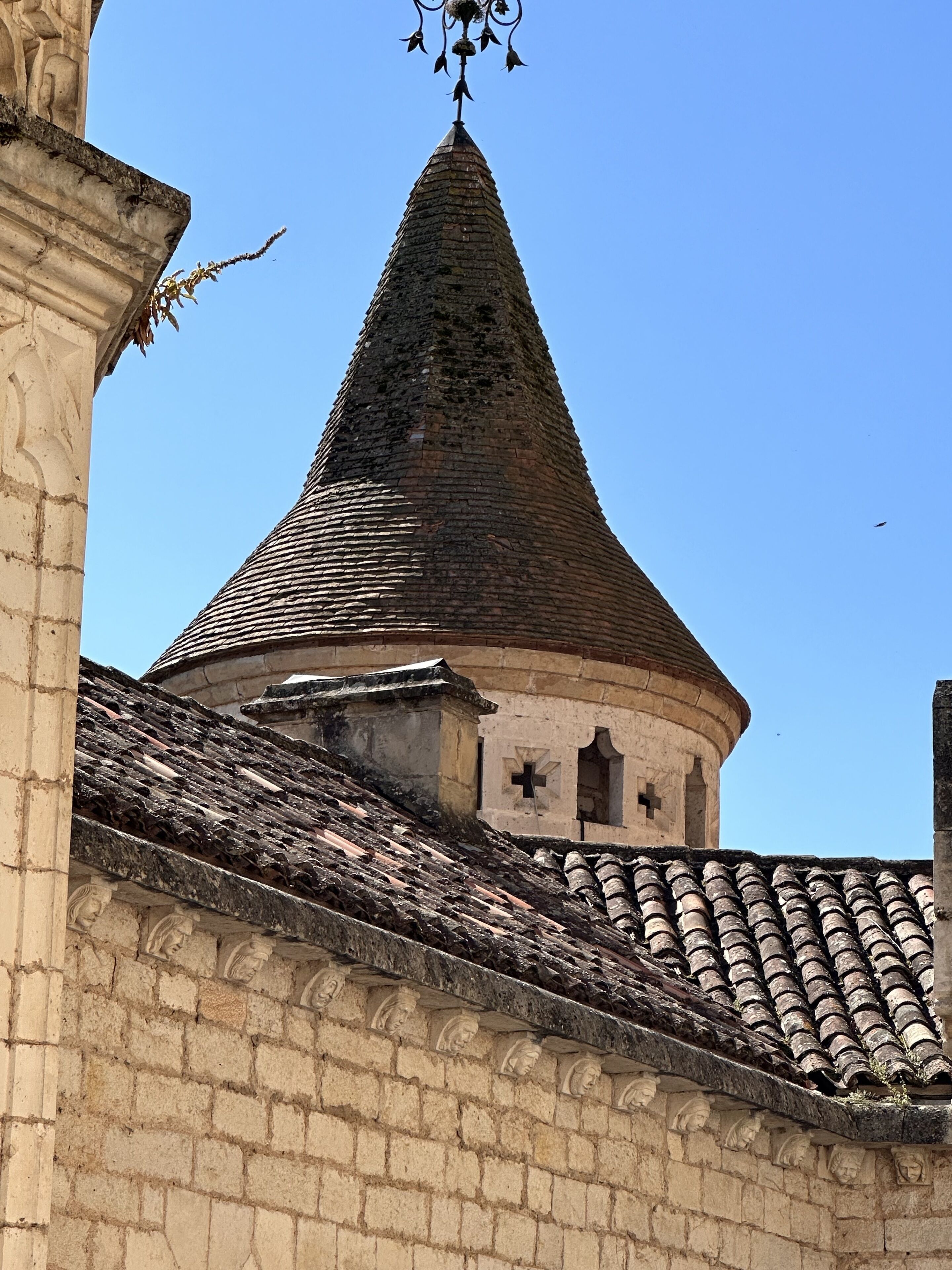 A historic building with a conical roof and a cross-shaped window.