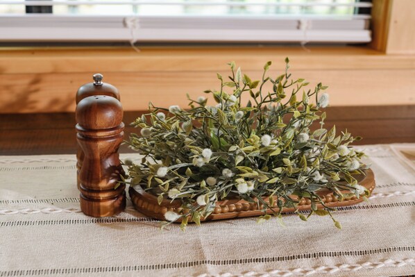 A wooden salt and pepper shaker and a terracotta pot with green foliage on a textured fabric surface. - The Bellefonte Campground (Bellefonte)
