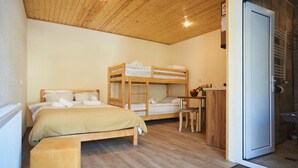 Une chambre avec un lit simple, un lit superposé et un bureau avec une chaise.