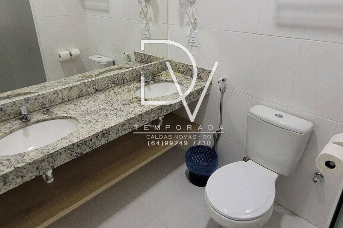 A modern bathroom with a marble sink, a toilet, and a mirror.