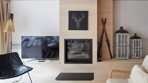 A modern living room with a flat-screen TV, a fireplace, and a wooden ceiling. - Casa Val de Ruda Luxe 71 by FeelFree Rentals (Baqueira)